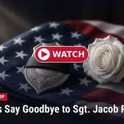 Fostoria News Memorial with American flag, white rose, and police badge for Sgt. Jacob Roesler.